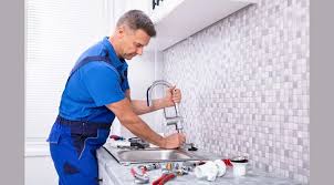 Skilled plumber repairing kitchen pipes using professional tools during a home plumbing service.